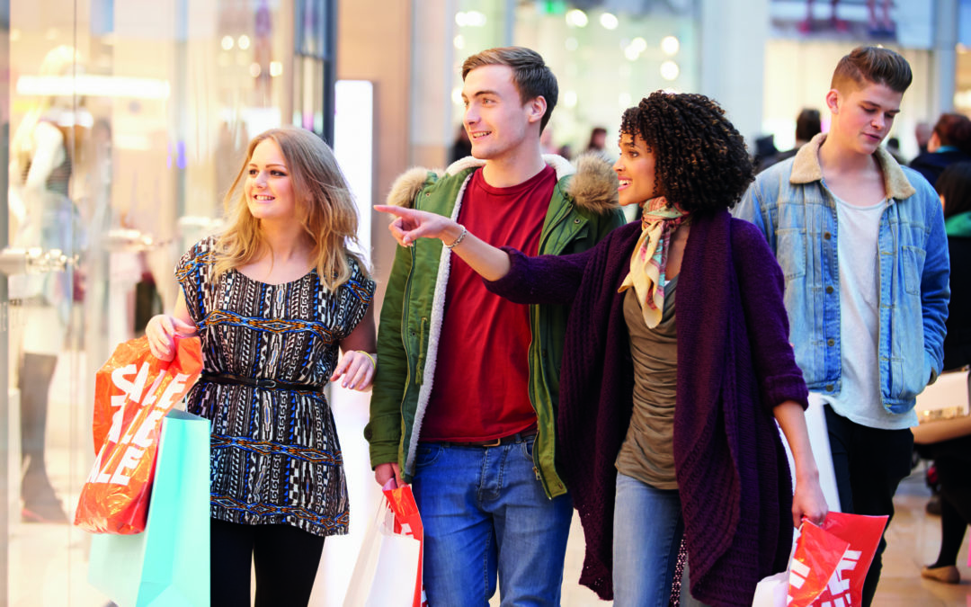 Mundschutz beugt Ansteckung vor: Eine Gruppe von Jugendlichen schlendert zusammen durch eine Einkaufsstraße