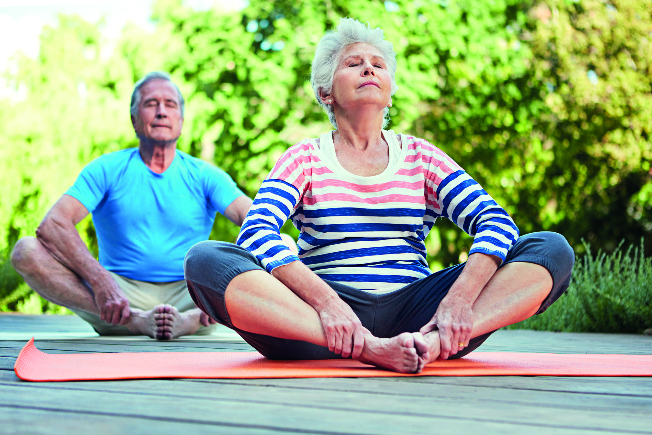 Senioren machen den Sonnengruß: Yoga unterstützt den Körper im Alter und beugt Krankheiten vor
