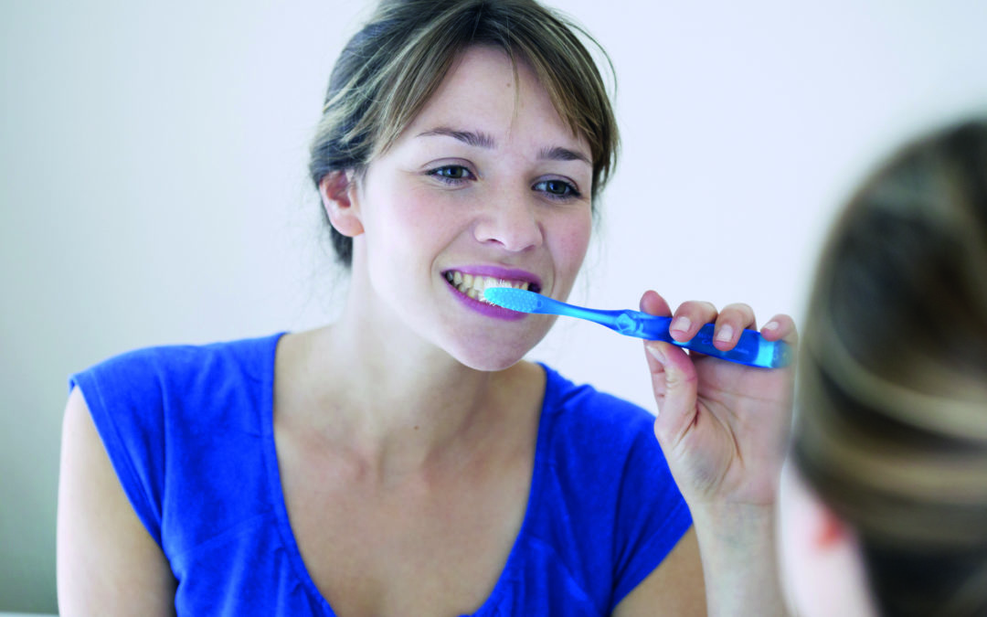 Eine Frau putzt sich ausführlich die Zähne, denn ihre Zahngesundheit ist ihr wichtig.